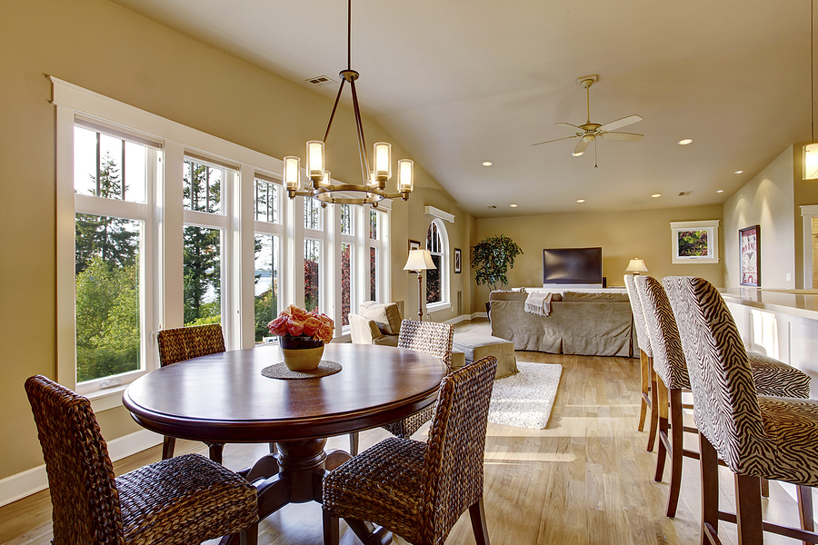 Open floor plan family room and dining room with large windows on a sunny day.