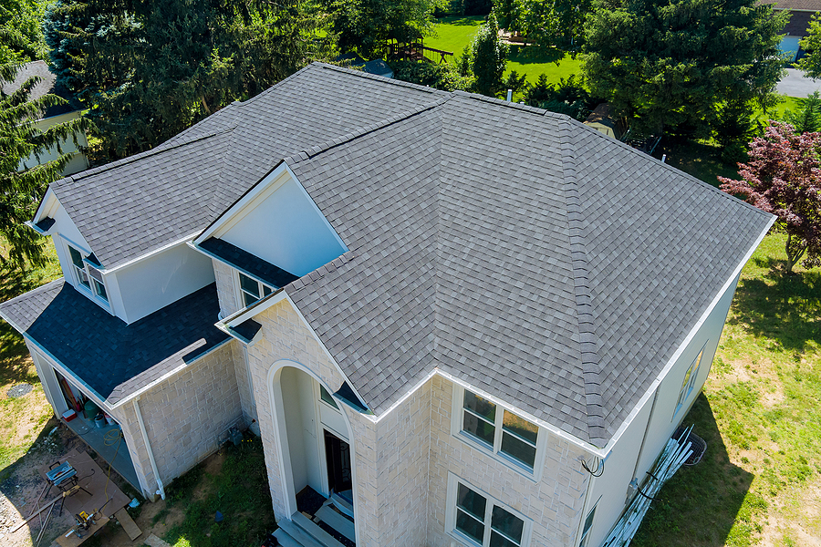 Aerial view of asphalt shingles construction site roofing the house.