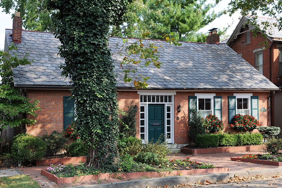 An small, well maintained urban brick home in early fall.