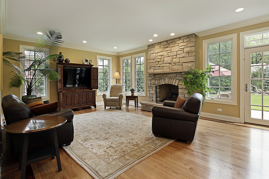 Family room in luxury home with stone fireplace and new windows.