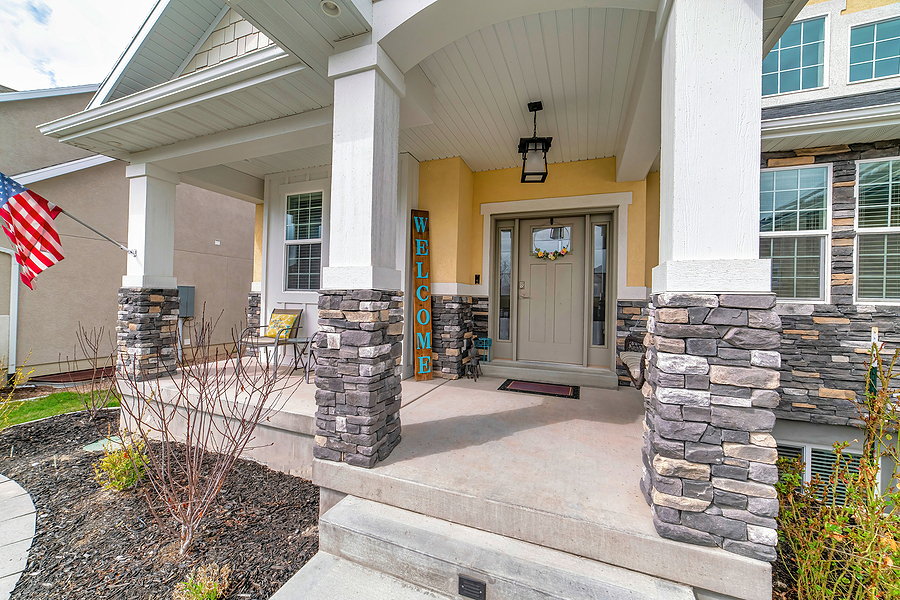 Home with arched entrance to the open porch and front door with sidelights.