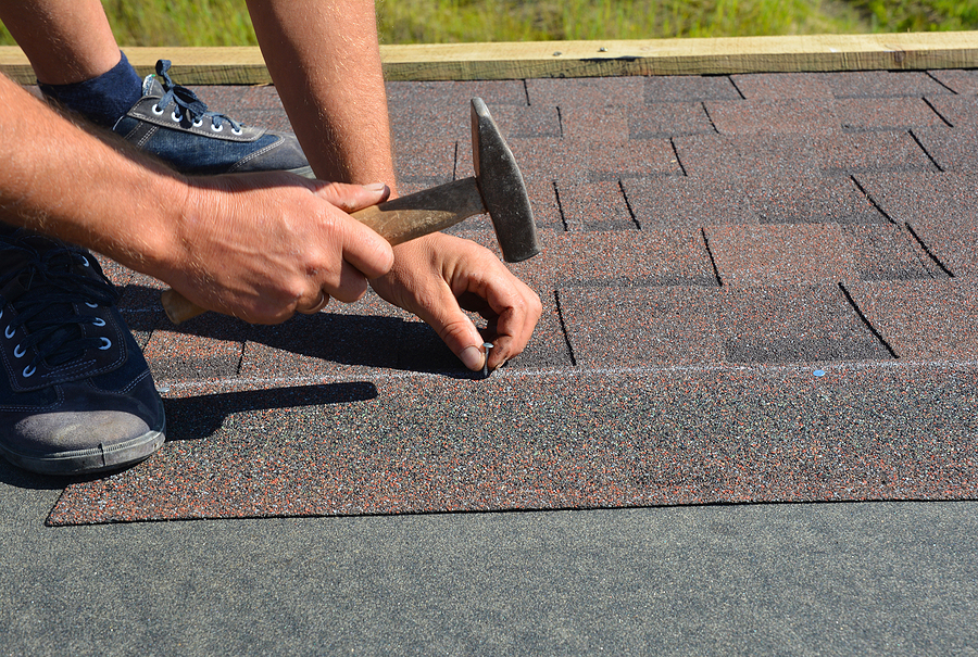 Roofer Installing Asphalt Shingles On House.